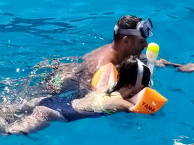 A parent and child enjoy snorkeling together in crystal-clear waters, creating unforgettable family memories while exploring the underwater world.