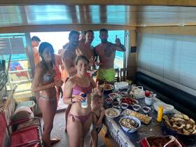 A lively group enjoys a spread of delicious snacks and drinks inside the boat, perfect for a fun day on the water.
