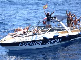 A lively group enjoys a sunny day on a boat, celebrating and having fun in the water — perfect for summer outings and party adventures.