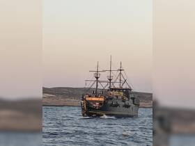 A lively pirate ship sails through the waters, filled with guests enjoying the adventure — perfect for themed cruises and group outings.