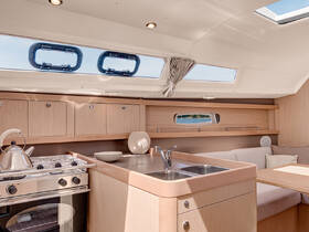 A beautifully designed interior of a boat featuring a modern kitchen area with a stove, sink, and cozy seating, perfect for comfortable living on the water.