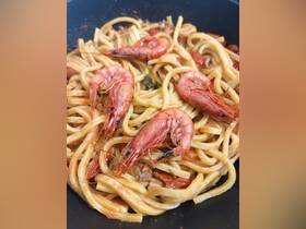 A delicious plate of shrimp pasta, showcasing fresh ingredients and vibrant colors, perfect for onboard dining experiences.