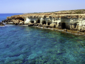A stunning view of rocky cliffs along a clear turquoise coastline, perfect for exploring the natural beauty of the area.