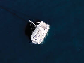 Aerial view of a sleek catamaran gliding through deep blue waters, showcasing its elegant design and perfect for luxury sailing adventures.