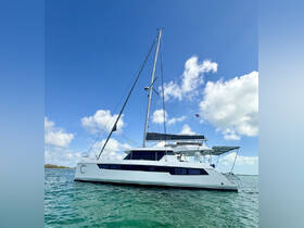 A stunning side view of a Leopard 42 catamaran cruising through clear waters, showcasing its sleek design and perfect for sailing adventures.