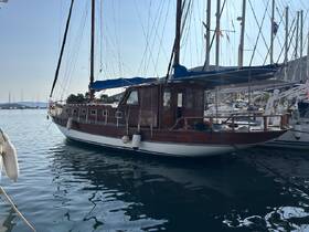 A beautiful wooden yacht docked in calm waters, showcasing its elegant design and tranquil surroundings — perfect for a relaxing getaway.