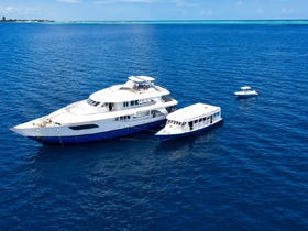 A stunning aerial view of a luxurious yacht cruising in deep blue waters, showcasing its elegant design and spacious layout, perfect for upscale charters.