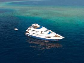 A stunning aerial view of a luxurious yacht cruising through crystal-clear waters, perfect for upscale charters and ocean adventures.