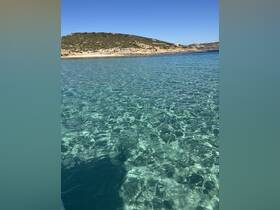 A stunning view of crystal-clear waters and a picturesque coastline, perfect for showcasing the beauty of a boating adventure.