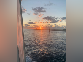 A stunning sunset view from a boat, showcasing vibrant colors reflecting on the water — perfect for serene evening cruises.