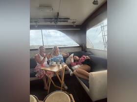 Three friends enjoy a relaxing moment inside the boat's lounge area, complete with drinks and a cozy atmosphere — perfect for unwinding during a day on the water.