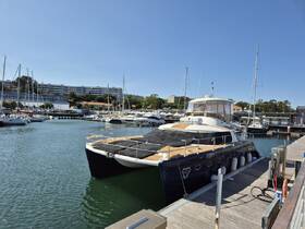 A stunning catamaran docked at the marina, showcasing its sleek design against a clear blue sky — perfect for luxury charters and sailing adventures.