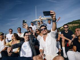 A lively group of friends captures a fun selfie aboard a boat, enjoying a memorable day on the water — perfect for celebrations and social gatherings.