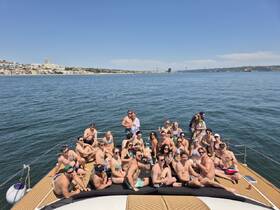 A lively group enjoys a sunny day aboard a yacht, celebrating with drinks and laughter — perfect for memorable gatherings on the water.