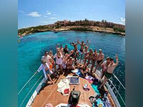 A lively group celebrates aboard a yacht, enjoying the sun and turquoise waters — perfect for unforgettable summer parties and gatherings.