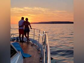 A couple enjoys a romantic sunset view from the deck of a yacht, creating the perfect backdrop for memorable moments on the water.