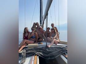 A joyful group enjoys a sailing trip, raising glasses in celebration on the deck of a yacht — perfect for family gatherings or special occasions on the water.