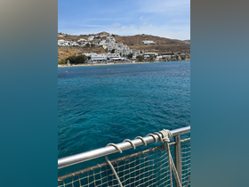 A stunning view of the coastline with turquoise waters, showcasing the beautiful landscape of Mykonos, perfect for a relaxing boat trip.