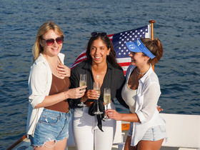 Three friends celebrate with cocktails on a yacht, enjoying a sunny day on the water — perfect for memorable gatherings and special occasions.