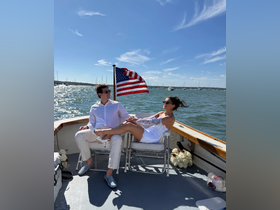 A couple enjoys a sunny day on a boat, showcasing a romantic atmosphere perfect for celebrations or special occasions on the water.