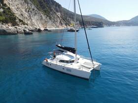 A stunning aerial view of a catamaran cruising through crystal-clear waters, showcasing the beauty of the coastline and the joy of sailing.