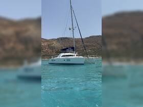 A beautiful catamaran anchored in clear turquoise waters, showcasing its elegant design against a stunning natural backdrop.