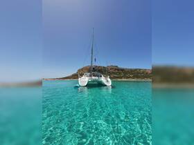 A stunning view of a catamaran anchored in crystal-clear waters, showcasing the beauty of a serene boating experience.