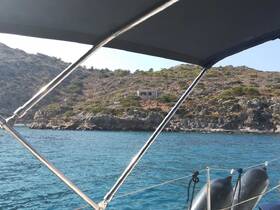 A picturesque view of a rocky coastline and a distant building, captured from a boat, showcasing the serene beauty of the surrounding waters.