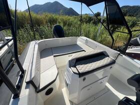 A well-appointed interior view of a boat's seating and helm area, showcasing comfortable lounge space ideal for relaxing while on the water.