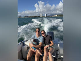A joyful family enjoys a boat ride, capturing a moment of happiness on the water with stunning scenery in the background.