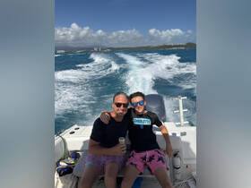 A father and son enjoy a fun day on the water, capturing the joy of family bonding while boating in beautiful ocean surroundings.