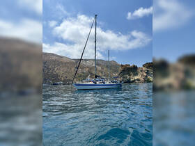 A picturesque sailboat glides through calm waters, framed by stunning coastal cliffs — perfect for sailing enthusiasts and scenic adventures.