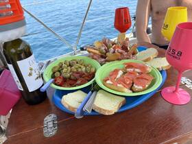 A vibrant spread of snacks and drinks on deck, featuring olives, cured meats, and wine, perfect for enjoying a relaxing day on the water.