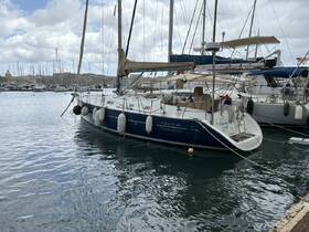A beautiful OCEANIS 411 yacht docked in a marina, showcasing its sleek design and serene surroundings — perfect for sailing enthusiasts and charter adventures.
