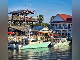 A scenic view of boats docked at a waterfront restaurant, showcasing the vibrant atmosphere of a popular boating destination.