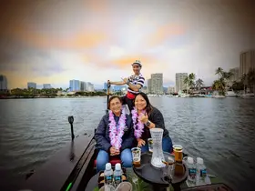 A joyful group enjoys a scenic boat ride with a stunning city backdrop, perfect for celebrations and memorable outings on the water.