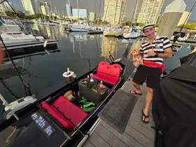 A man poses on a boat with a cooler and seating area, showcasing a fun and inviting atmosphere for a day on the water.