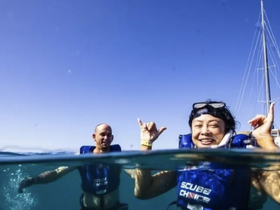 Two friends enjoy a fun snorkeling experience, showcasing their excitement in the clear waters — perfect for adventure seekers looking to explore marine life.