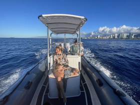 A family enjoys a scenic boat ride with a stunning cityscape in the background, capturing a perfect moment of relaxation on the water.