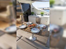A beautifully arranged dining table on a yacht, featuring delicious pasta, fresh salad, and cocktails, perfect for onboard dining experiences.