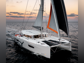 A stunning aerial view of a sleek catamaran sailing through open waters at sunset, showcasing its elegant design and vibrant sails.