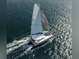 Aerial view of a sleek catamaran sailing through shimmering waters, showcasing its elegant design and perfect for adventurous outings on the sea.