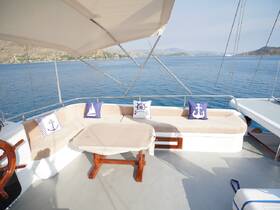 A cozy lounge area on a yacht featuring comfortable seating and nautical-themed pillows, perfect for relaxing while enjoying the stunning views of the sea.