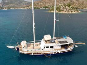 A stunning aerial view of a yacht anchored in clear blue waters, showcasing its elegant design and spacious deck, perfect for luxurious sailing adventures.