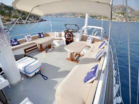 A spacious interior view of a yacht's cabin featuring comfortable seating and a helm, perfect for relaxing while enjoying the scenic waters.