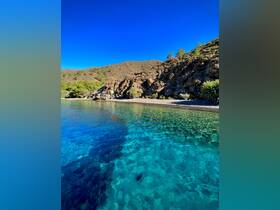 A stunning view of a serene coastline with crystal-clear waters, perfect for exploring and enjoying nature's beauty.