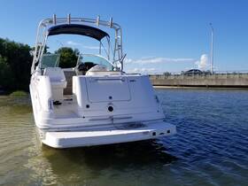 A sleek speedboat is docked in calm waters, showcasing its elegant design against a clear blue sky — perfect for a day on the water.