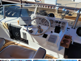 A detailed view of the helm and console area inside a boat, showcasing the steering wheel and Garmin navigation system, ideal for navigating the waters.