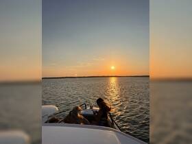 A group enjoys a picturesque sunset on the water, creating a perfect backdrop for memorable moments aboard the boat.