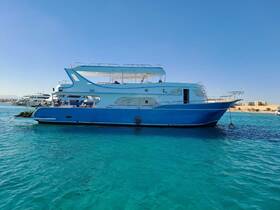 A stunning blue yacht anchored in clear turquoise waters, showcasing its sleek design against a picturesque backdrop.